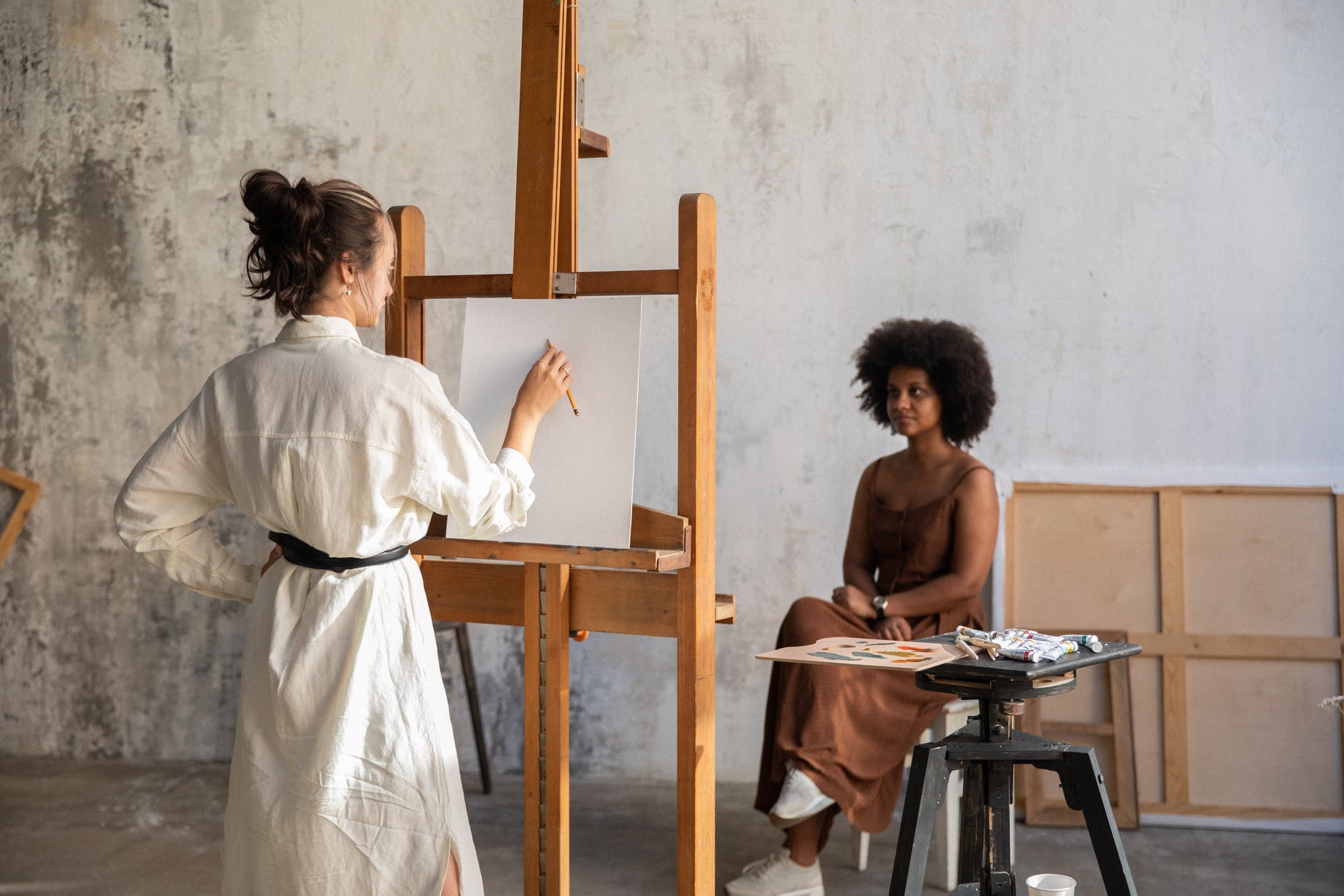 an image of an artist painting a woman